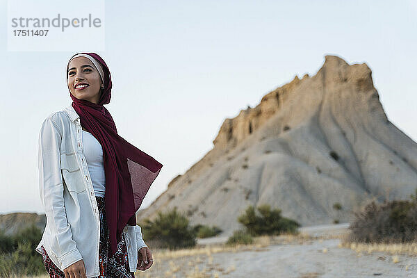 Lächelnde junge Touristin mit Hijab in Wüstenlandschaft
