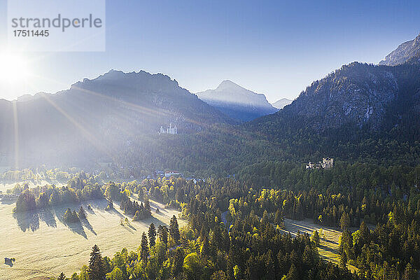 Germany  Bavaria  Schwangau  Rising sun illuminating Neuschwanstein Castle and Hohenschwangau Castle