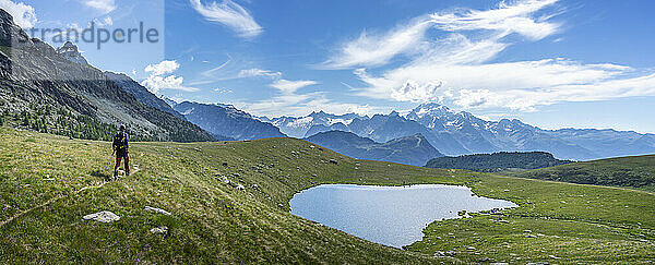 Wanderer wandert in der Nähe eines Sees auf einem Berg in den westlichen Rätischen Alpen  Sondrio  Italien