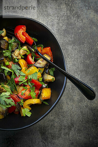 Schüssel mit gebratenem veganem Salat mit Auberginen  Paprika und Petersilie