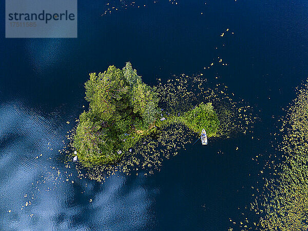 Luftaufnahme eines Bootes  das am Ufer einer kleinen grünen Insel am Fluss Vuoksi zurückgelassen wurde