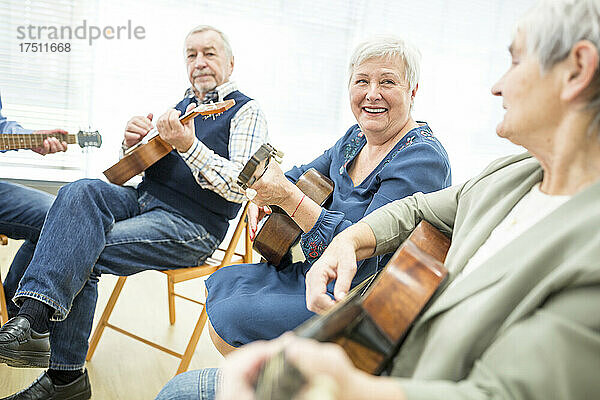 Senioren im Altersheim besuchen Gitarrenunterricht und machen Musik