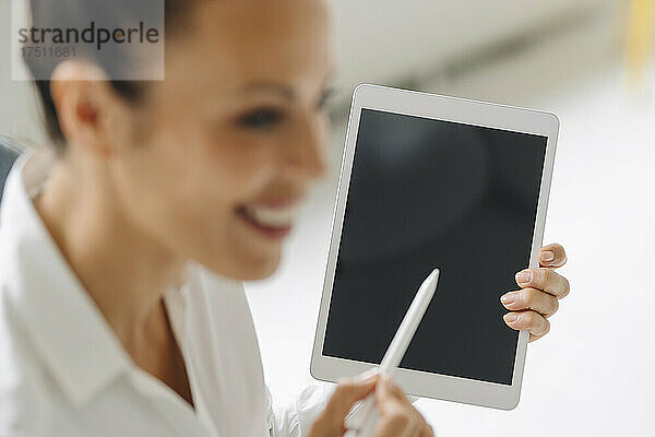 Nahaufnahme einer Unternehmerin  die im Heimbüro ein digitales Tablet nutzt