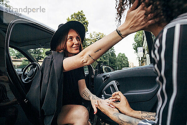 Freund trägt Verlobungsring für liebevolle Freundin  die im Auto sitzt