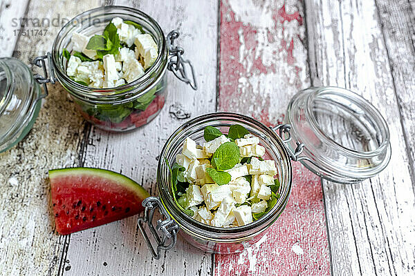 Watermelon slice and jars of watermelon salad with feta cheese  corn salad and mint