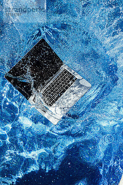 Erhöhte Ansicht eines Computers  der in ein Schwimmbad fällt