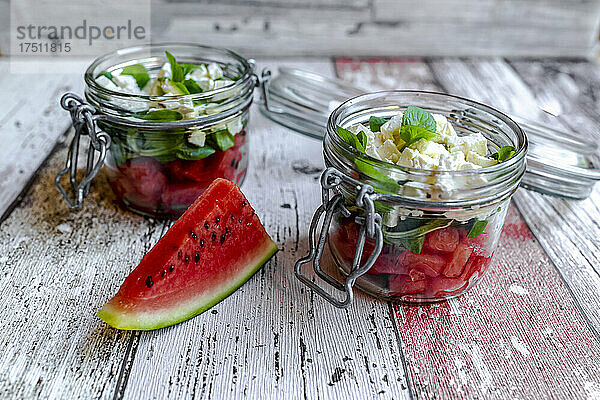 Wassermelonenscheibe und Gläser Wassermelonensalat mit Feta-Käse  Maissalat und Minze