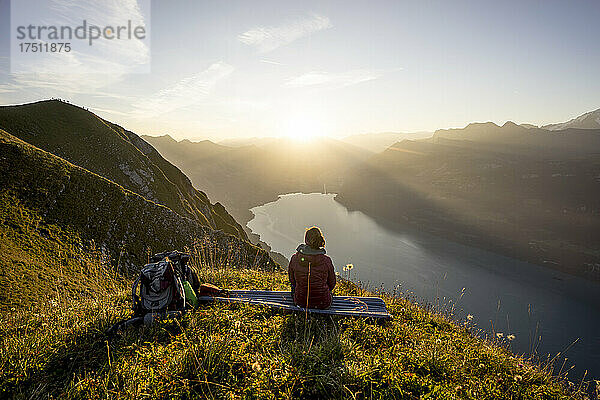 Wanderin sitzt bei Sonnenuntergang auf einem Aussichtspunkt  Augstmatthorn  Schweiz