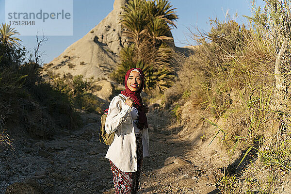 Lächelnde junge Touristin mit Hijab auf einer Wanderung