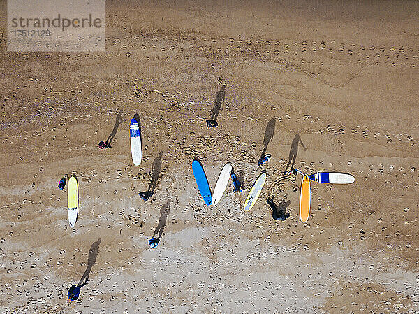 Luftaufnahme von Surfern  die sich am sandigen Küstenstrand vorbereiten