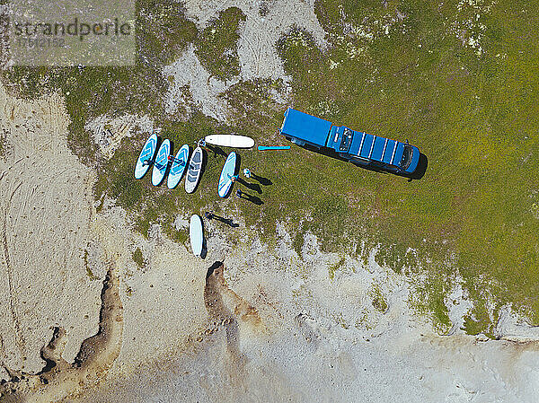 Aerial view of surfers preparing on sandy riverbank
