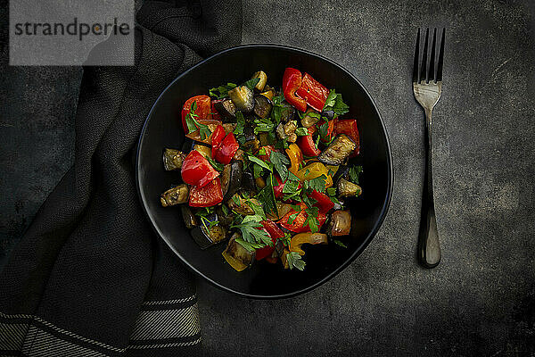 Schüssel mit gebratenem veganem Salat mit Auberginen  Paprika und Petersilie
