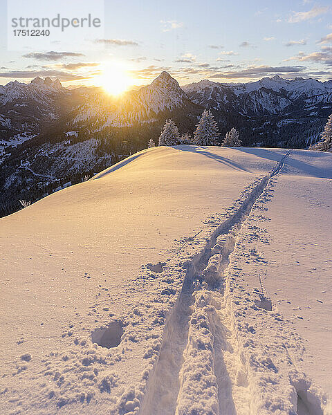 Skipisten auf dem schneebedeckten Gipfel des Schonkahler Berges bei Sonnenaufgang