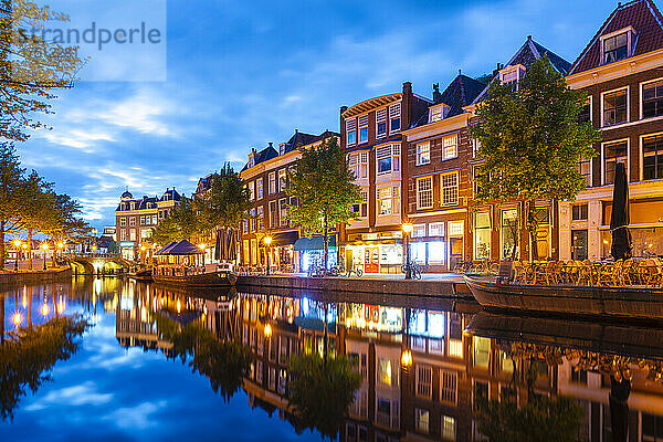 Niederlande  Südholland  Leiden  Reihe von Stadthäusern  die sich in der Abenddämmerung im Nieuwe-Rijn-Kanal spiegeln