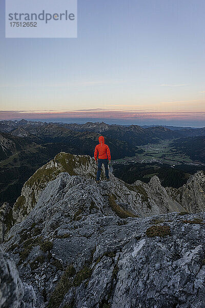 Rückansicht eines Wanderers am Aussichtspunkt bei Sonnenaufgang  Gimpel  Tirol  Österreich