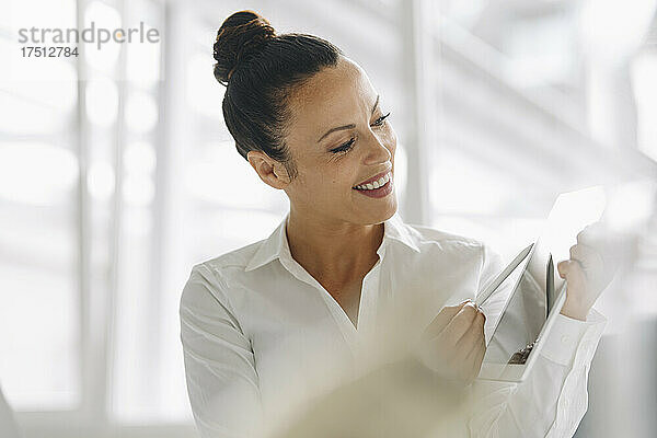 Nahaufnahme einer lächelnden Geschäftsfrau  die im Heimbüro ein digitales Tablet nutzt