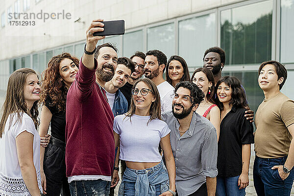 Mann macht Selfie mit einer Gruppe von Freunden in der Stadt