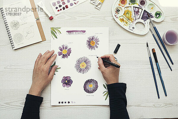 Woman painting flowers with water colors  top view