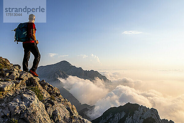 Mann bewundert die Aussicht  während er auf dem Berggipfel der Bergamasker Alpen  Italien  steht