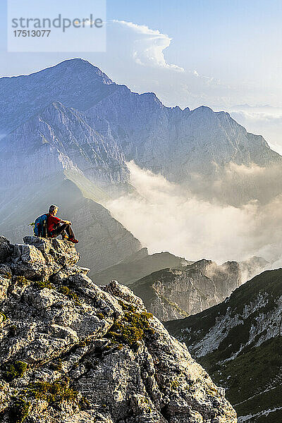 Wanderer bewundern die Aussicht  während er auf dem Berggipfel der Bergamasker Alpen  Italien  sitzt