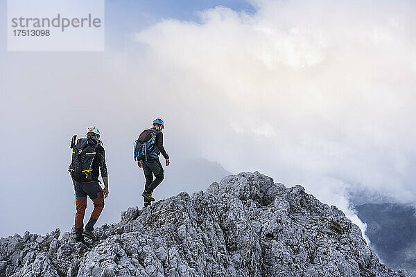 Reife Männer wandern auf einem Berg gegen bewölkten Himmel  Bergamasker Alpen  Italien