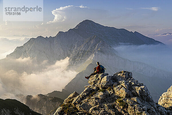 Wanderer sitzt auf dem Berggipfel der Bergamasker Alpen  Italien