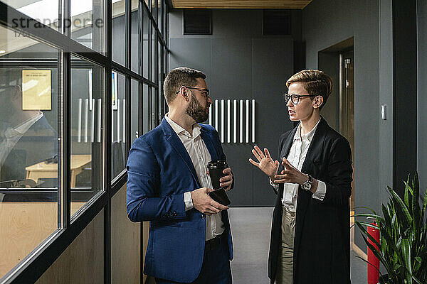 Unternehmer diskutieren während der Strategieplanung im Coworking-Bürokorridor