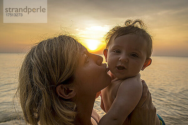 Vietnam  Insel Phu Quoc  Strand von Ong Lang  Mutter küsst ihr Baby am Strand bei Sonnenuntergang