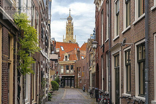 Niederlande  Nordholland  Haarlem  leere Gasse zwischen alten historischen Häusern mit dem Turm der Bakenesserkerk im Hintergrund