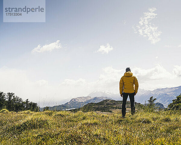 Mann blickt auf die Aussicht  während er auf einem Berg in Patagonien  Argentinien  Südamerika steht