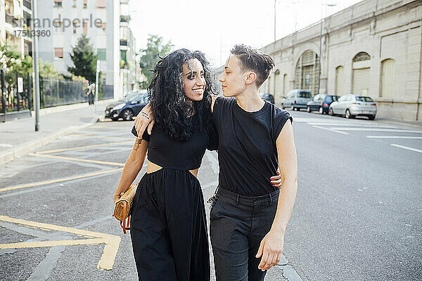 Lächelndes lesbisches Paar  das durch die Stadt spaziert