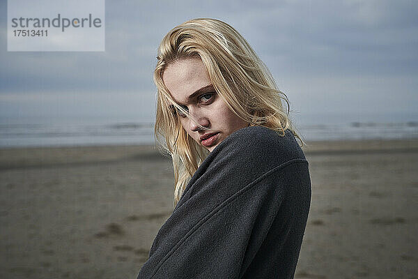 Porträt einer blonden jungen Frau am Strand