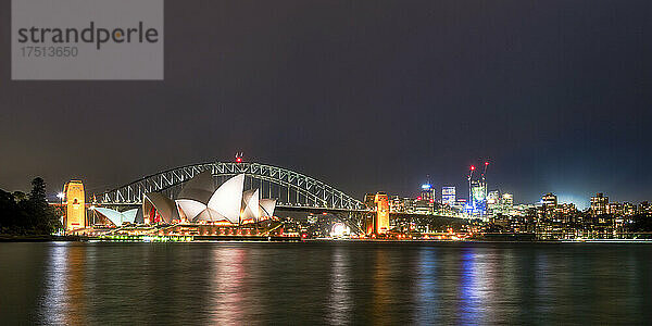 Beleuchtete Sydney Harbour Bridge und Gebäude über dem Fluss gegen den nächtlichen Himmel  Australien