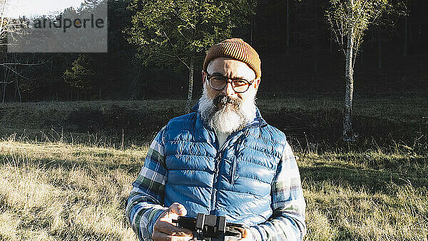 Porträt eines Mannes  der die Fernbedienung einer Drohne bedient.