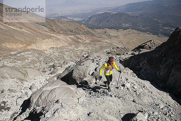 Ein Mann mit Stöcken wandert durch unwegsames Gelände am Pico de Orizaba