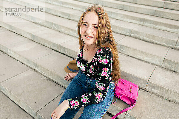 Teenager-Mädchen liegt mit Accessoires auf der Treppe