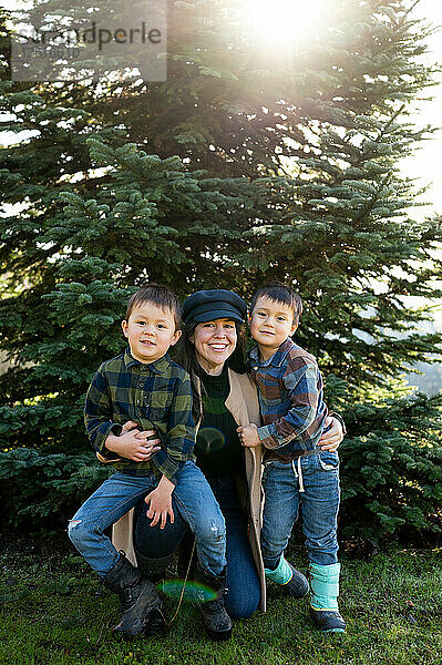 Porträt einer Mutter und ihrer Söhne vor dem Weihnachtsbaum