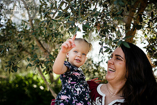 Mutter und Tochter unter Baum im Garten in Kalifornien