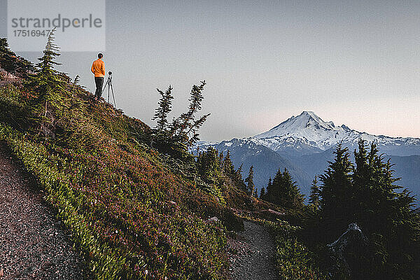 Ein Mann mit einer Kamera fotografiert Berge in North Cascades