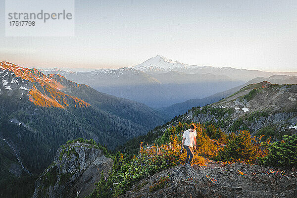 Ein Mann mit einer Kamera geht in North Cascades in der Nähe des Berges spazieren. Bäcker