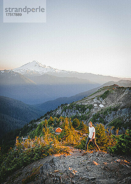 Ein Mann geht in der Nähe eines Zeltes in North Cascades in der Nähe des Berges hinauf. Bäcker