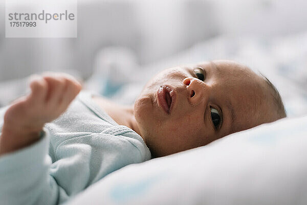 Porträt eines neugeborenen Babys  das im Bett liegt. Seitenansicht.