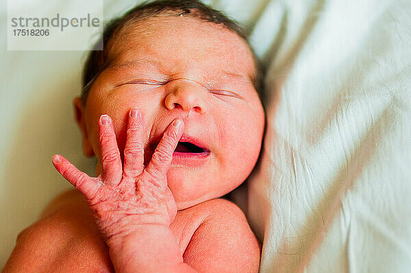 Gesicht und Hand des Neugeborenen