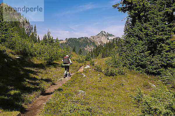 Frauen wandern mit dem Rucksack durch die Wasserfälle auf einem Wanderweg