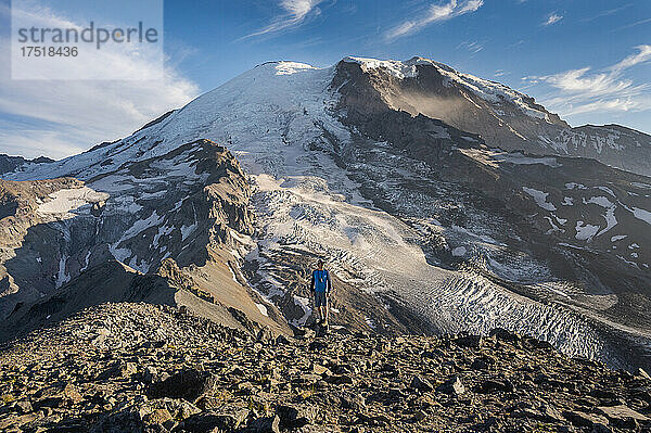 Mann mit Fernglas steht vor dem Mount Rainier