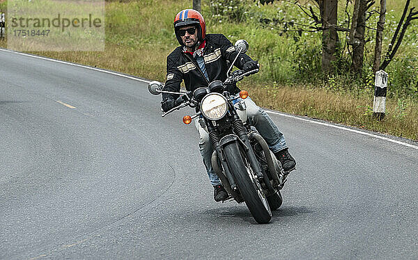 Mann fährt mit seinem klassischen Motorrad im Khao Yai Nationalpark