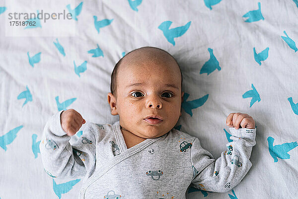 Porträt eines einen Monat alten Babys  das auf einem Bett liegt