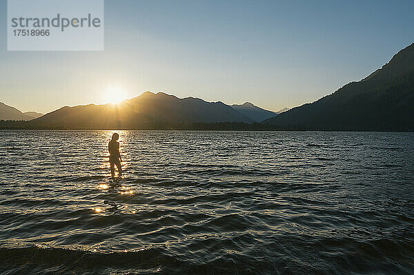 Frau schwimmt im Bikini bei Sonnenuntergang am Lake Wenatchee