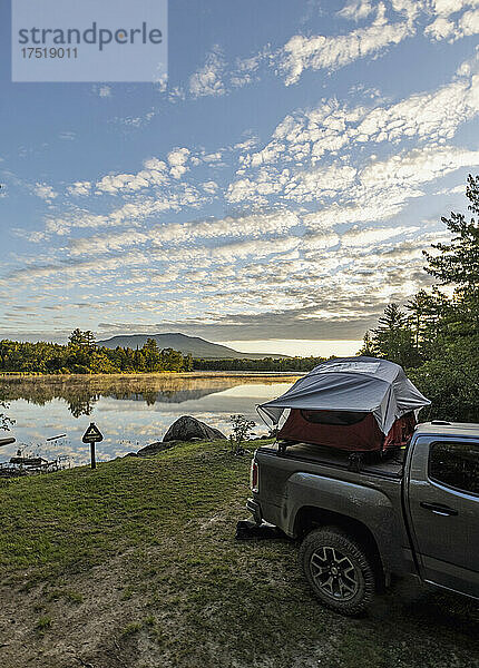 LKW mit Zelt steht neben einem friedlichen Fluss mit Berg  Maine
