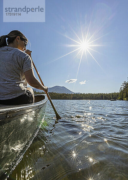 Junge Frau paddelt Kanu auf Daicey Pond  Maine. Katahdin in der Ferne.